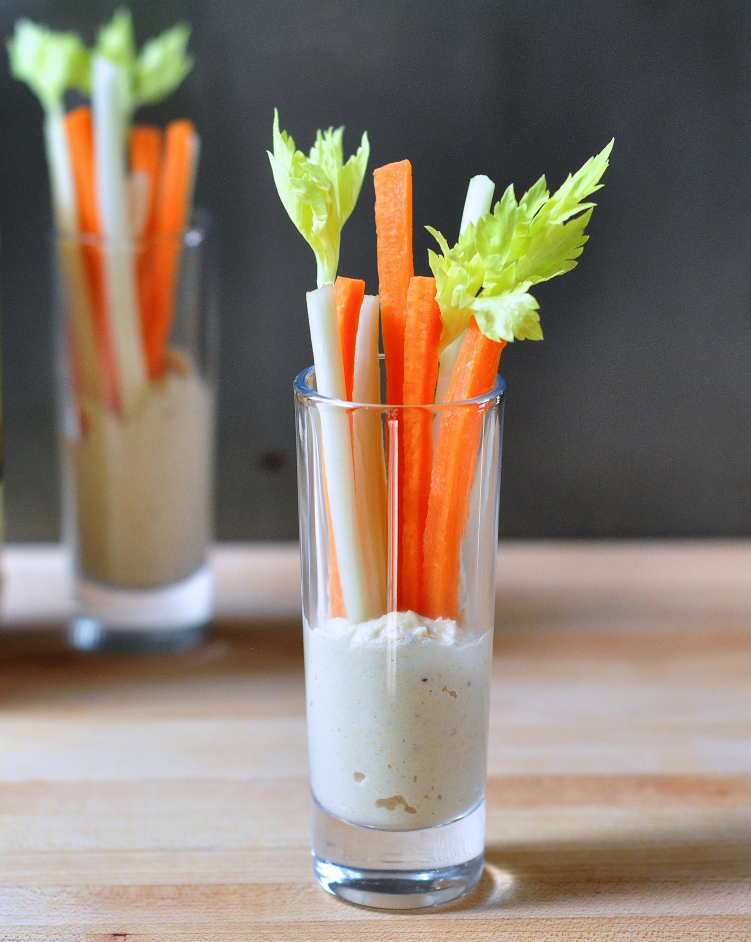 shot glasses of hummus and veggies